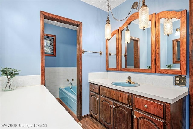 full bathroom with wood finished floors, a bath, and vanity