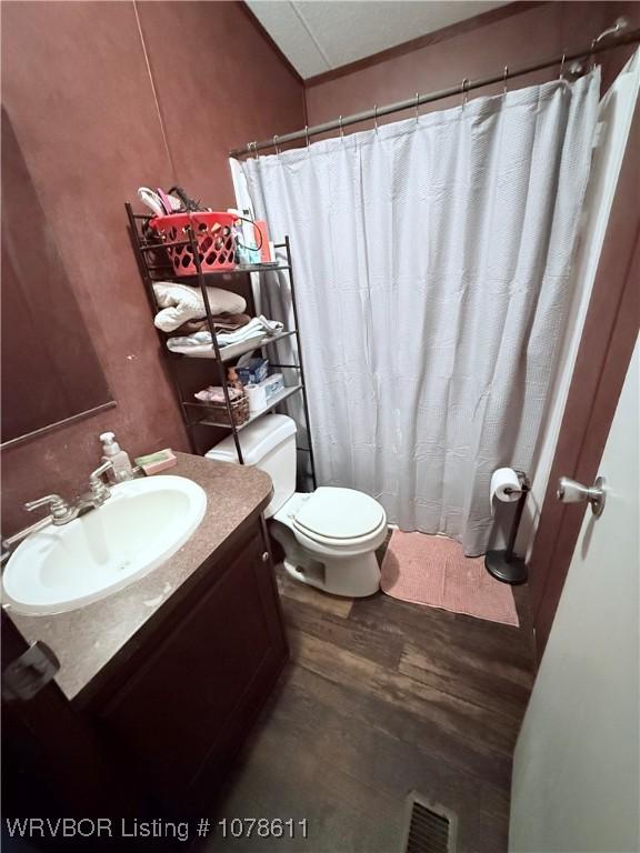 205 Lee Ordner, Panama, OK 74951 - full bath with visible vents, toilet, a shower with curtain, wood finished floors, and vanity