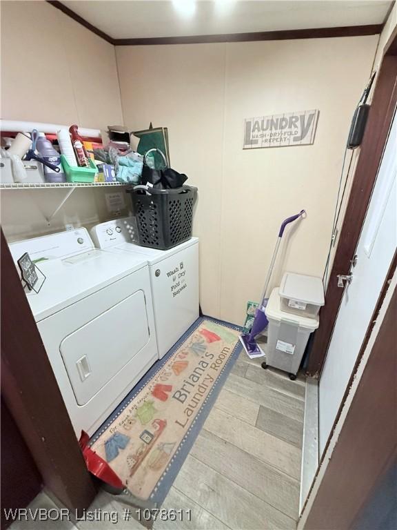 205 Lee Ordner, Panama, OK 74951 - laundry room with washing machine and clothes dryer, laundry area, light wood-type flooring, and ornamental molding