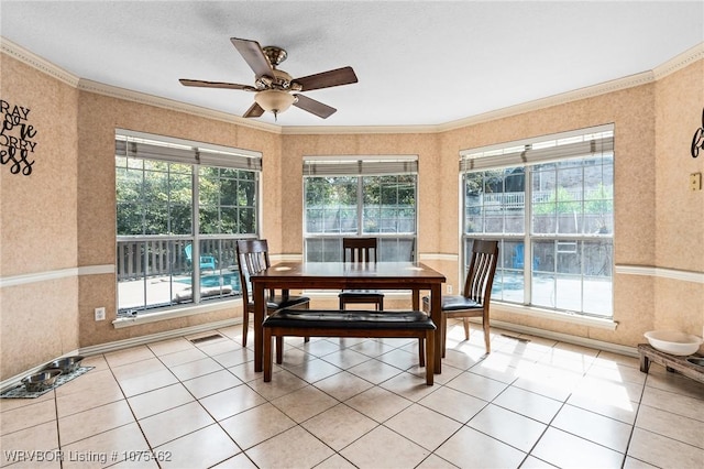 tiled dining area featuring ceiling fan and crown molding