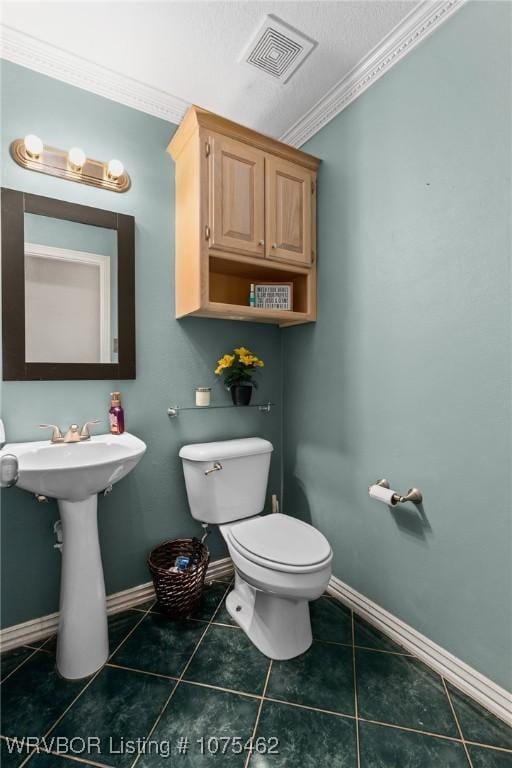 bathroom featuring tile patterned flooring, toilet, crown molding, and sink