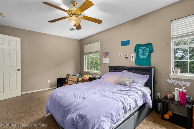 carpeted bedroom featuring ceiling fan and multiple windows