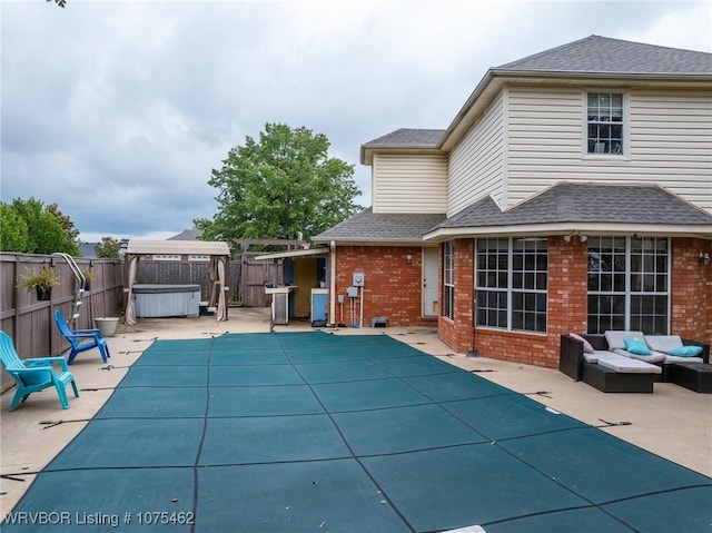 view of swimming pool featuring an outdoor living space, a patio, and a hot tub