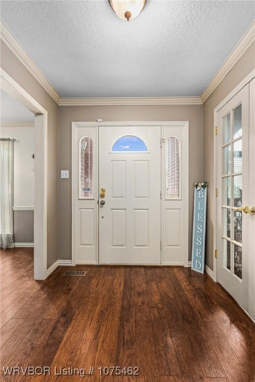 entrance foyer with a textured ceiling, crown molding, dark wood-type flooring, and french doors