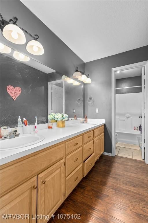 full bathroom featuring bathtub / shower combination, vanity, hardwood / wood-style flooring, and toilet