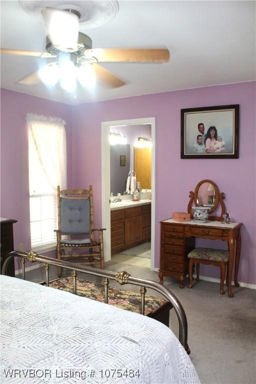 carpeted bedroom featuring ceiling fan and connected bathroom