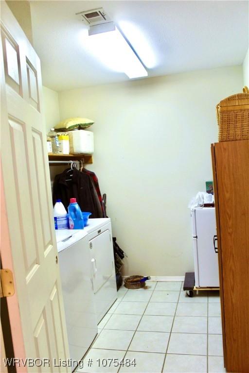 washroom with washer and dryer and light tile patterned floors