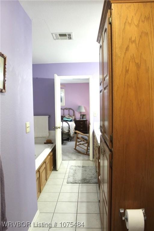 bathroom with tile patterned floors and a tub to relax in