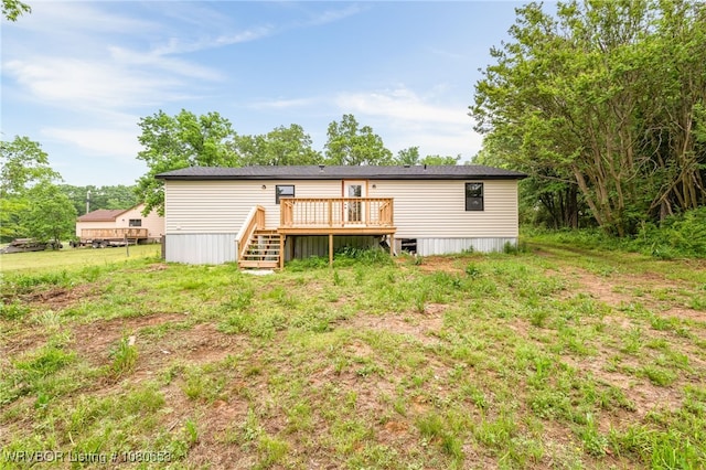 rear view of property with stairway and a deck