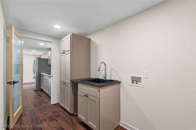 washroom featuring cabinet space, a sink, hookup for a washing machine, recessed lighting, and dark wood-type flooring