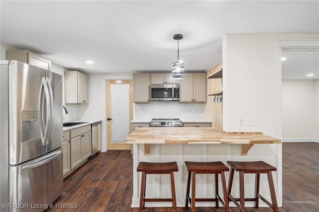 kitchen featuring butcher block counters, gray cabinets, tasteful backsplash, a sink, and appliances with stainless steel finishes