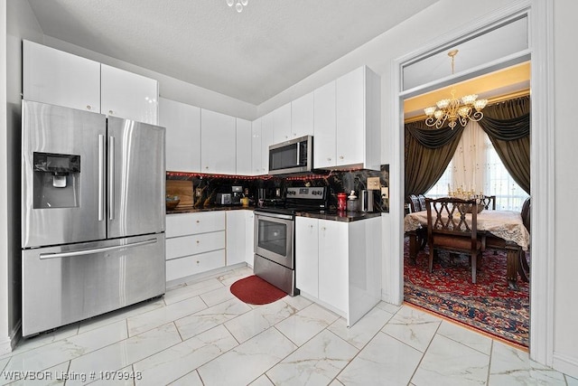 6408 Southfield Dr, Fort Smith, AR 72916 - kitchen with an inviting chandelier, marble finish floor, dark countertops, and appliances with stainless steel finishes
