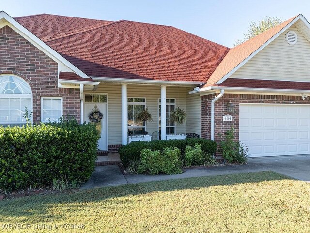 6408 Southfield Dr, Fort Smith, AR 72916 - view of front of property with a garage, brick siding, a front lawn, driveway, and covered porch