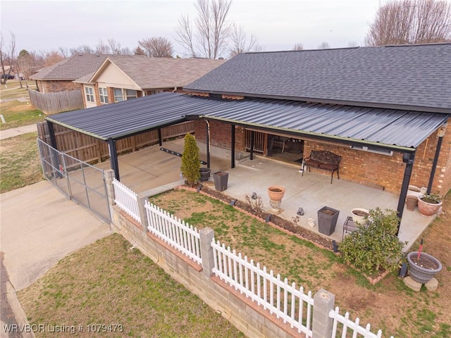 exterior space featuring an outbuilding, an exterior structure, roof with shingles, metal roof, and brick siding