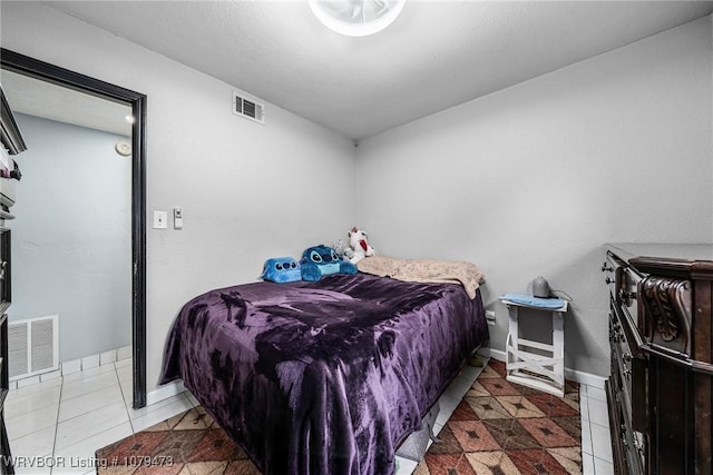 bedroom with tile patterned flooring, visible vents, and baseboards