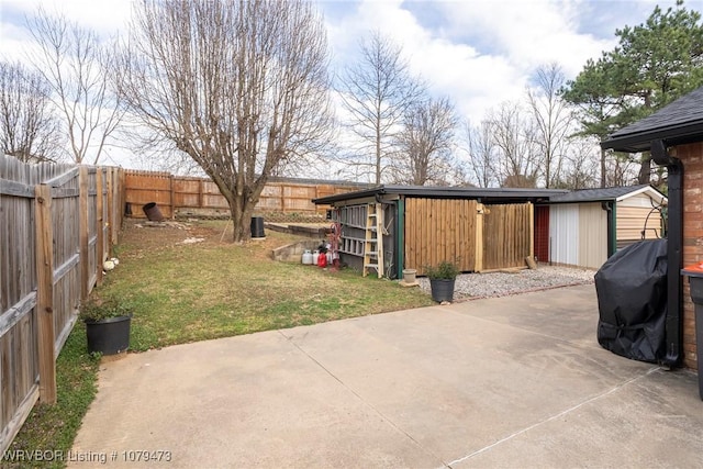 view of patio / terrace with a storage shed, an outdoor structure, area for grilling, and a fenced backyard