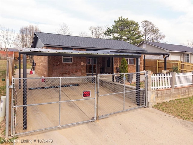 ranch-style home featuring brick siding, fence, roof with shingles, and a gate