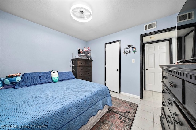 bedroom featuring light tile patterned floors, visible vents, and baseboards