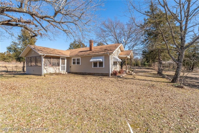 rear view of property featuring a sunroom