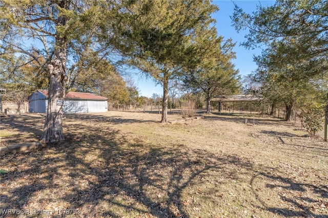 view of yard with a rural view and an outdoor structure