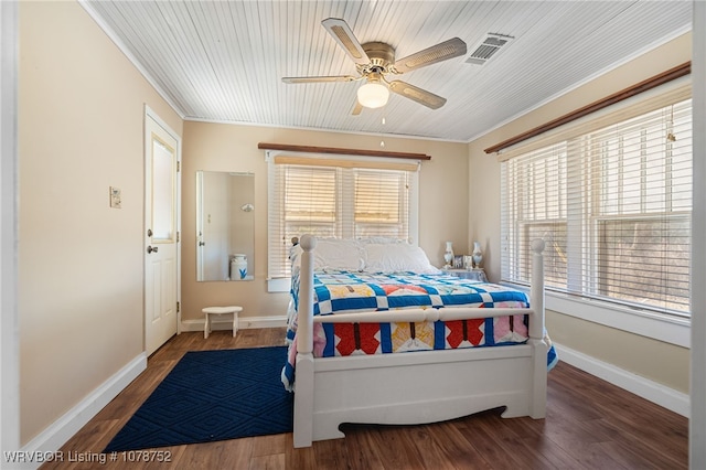 bedroom featuring multiple windows, hardwood / wood-style floors, and ornamental molding