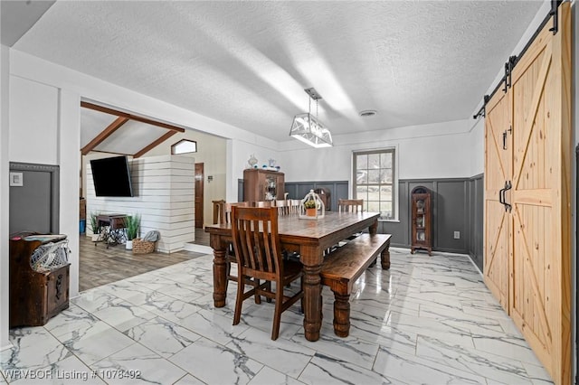 dining room featuring a textured ceiling and a barn door