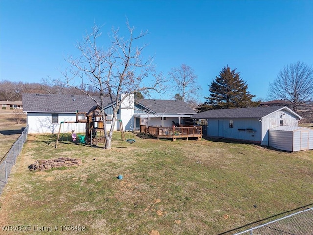 view of yard with a playground, a deck, and a shed