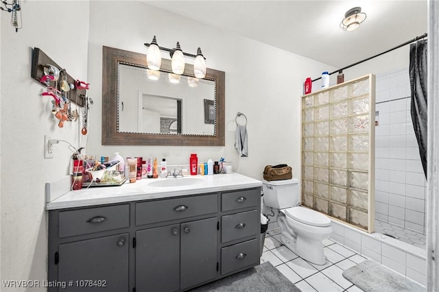 bathroom with toilet, a tile shower, tile patterned floors, and vanity