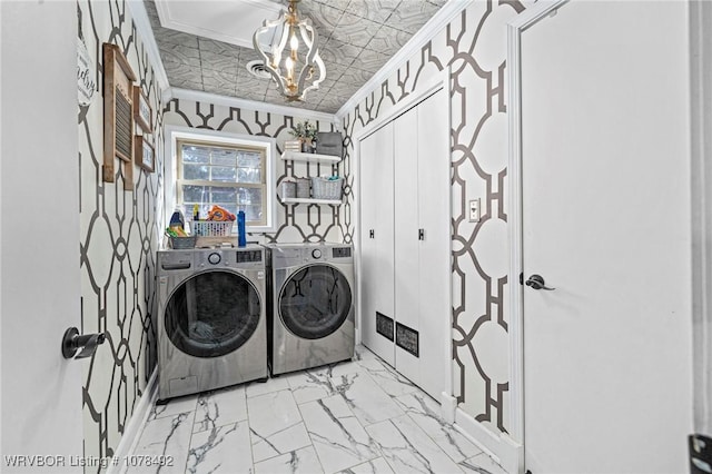 washroom with ornamental molding, independent washer and dryer, and a notable chandelier