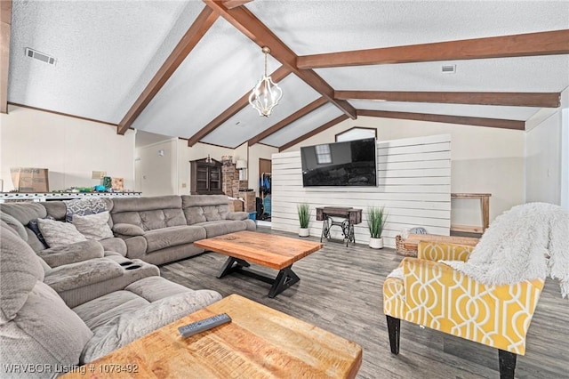 living room with a textured ceiling, hardwood / wood-style floors, and lofted ceiling with beams