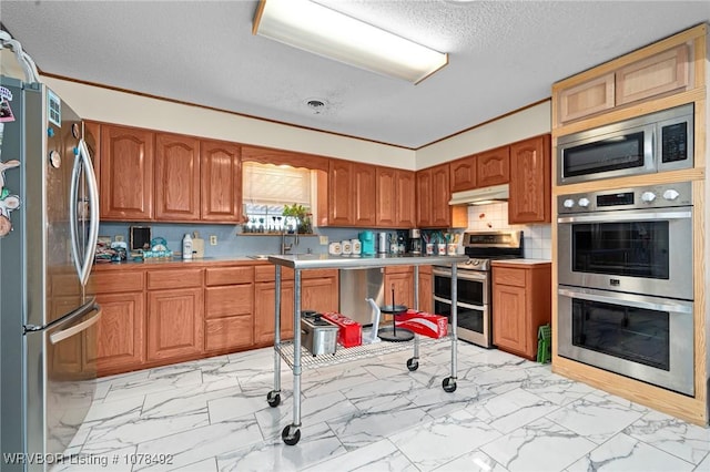 kitchen featuring sink, backsplash, appliances with stainless steel finishes, and ornamental molding