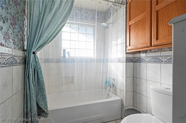 bathroom featuring toilet, tiled shower / bath, and tile walls