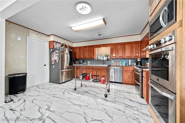 kitchen featuring a textured ceiling, appliances with stainless steel finishes, and crown molding