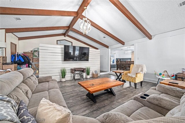 living room with a textured ceiling, a chandelier, wood-type flooring, and vaulted ceiling with beams