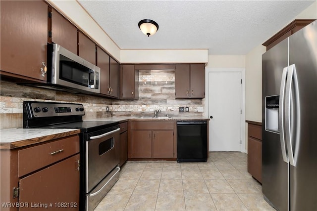 105 N Circle B, Roland, OK 74954 - kitchen with appliances with stainless steel finishes, decorative backsplash, a textured ceiling, light tile patterned floors, and dark brown cabinets
