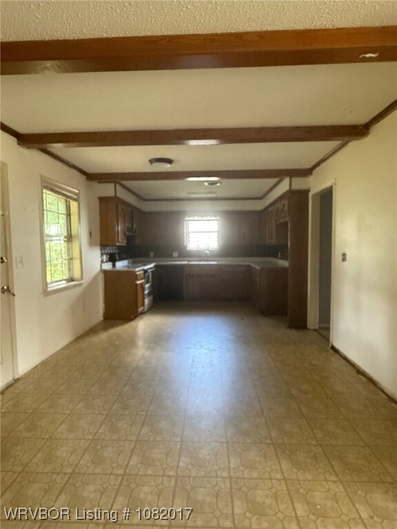 403 Woodland Hills Blvd, Roland, OK 74954 - kitchen with beamed ceiling, electric range oven, and light floors
