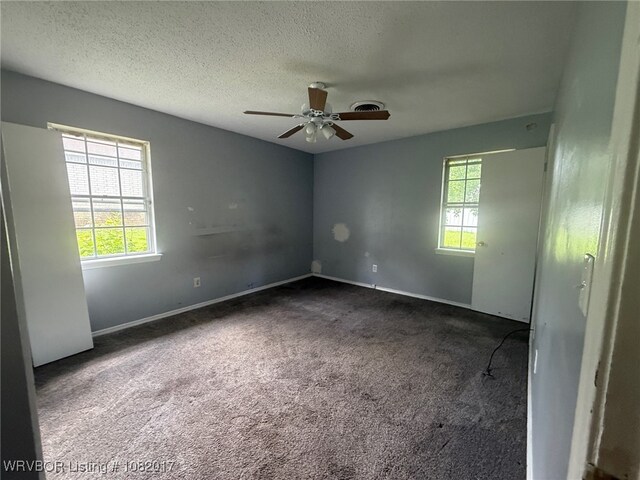 403 Woodland Hills Blvd, Roland, OK 74954 - spare room featuring healthy amount of natural light, carpet flooring, ceiling fan, and a textured ceiling