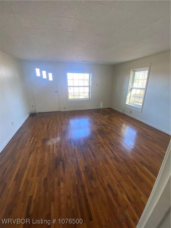 empty room featuring dark hardwood / wood-style flooring and plenty of natural light