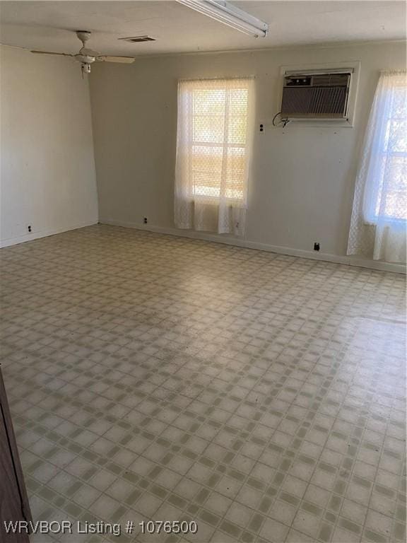 empty room with a wall mounted air conditioner and ceiling fan