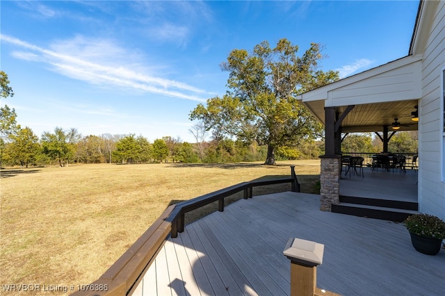 deck with a lawn and ceiling fan