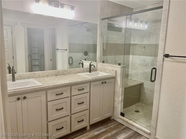 bathroom featuring hardwood / wood-style flooring, vanity, and an enclosed shower