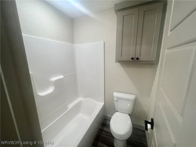 bathroom featuring shower / washtub combination and toilet