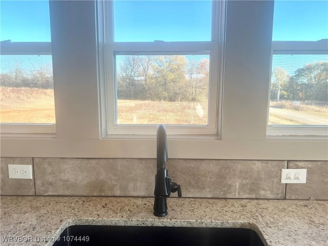 room details featuring light stone counters and sink