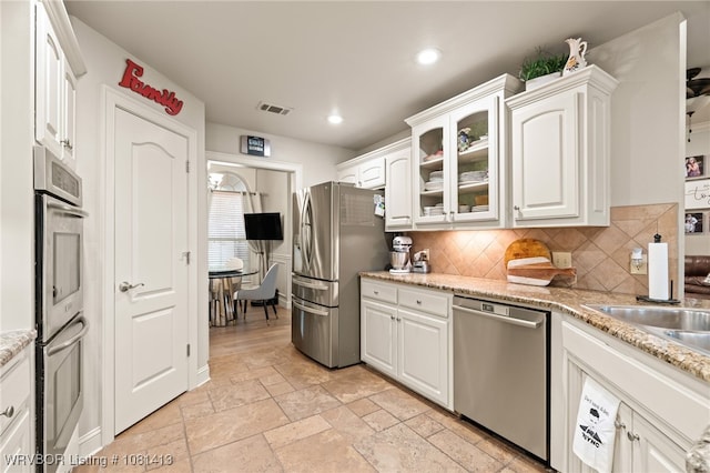 2110 Parkway Cir, Van Buren, AR 72956 - kitchen featuring appliances with stainless steel finishes, white cabinetry, decorative backsplash, stone tile floors, and recessed lighting