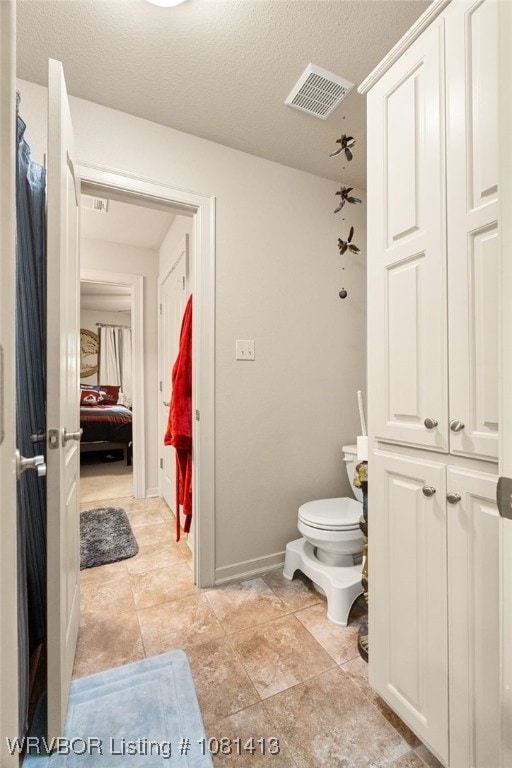 2110 Parkway Cir, Van Buren, AR 72956 - ensuite bathroom with toilet, a textured ceiling, and baseboards