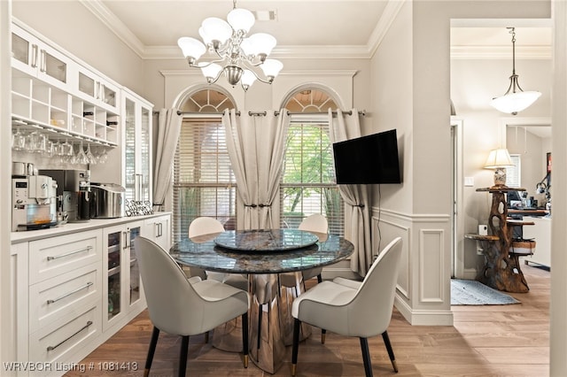 2110 Parkway Cir, Van Buren, AR 72956 - dining space featuring a chandelier, light wood finished floors, ornamental molding, bar, and a wainscoted wall