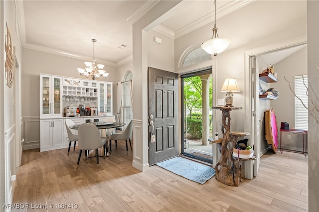 2110 Parkway Cir, Van Buren, AR 72956 - foyer with light wood-style floors, a chandelier, ornamental molding, and a wainscoted wall