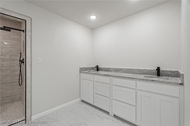 bathroom featuring baseboards, tiled shower, marble finish floors, double vanity, and recessed lighting
