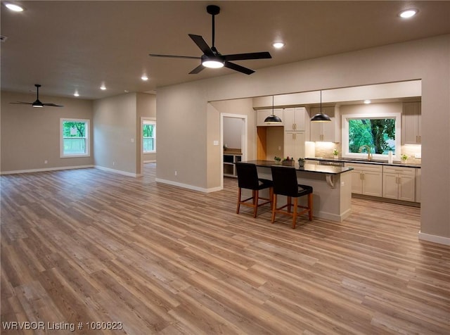 6001 Bolton Rd, Fort Smith, AR 72903 - kitchen featuring a ceiling fan, dark countertops, open floor plan, white cabinetry, and light wood-type flooring
