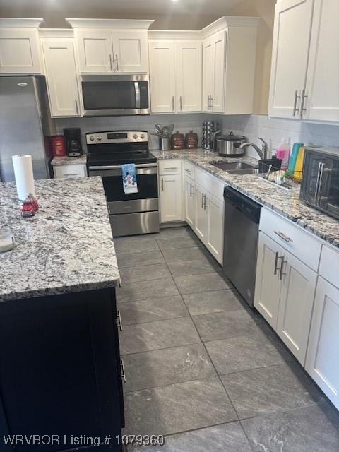 kitchen featuring stainless steel appliances, white cabinets, and a sink